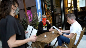 Owner Samantha DiStefano, left, prepares to hand menus to patrons and neighborhood regulars, Tuesday, Sept. 29, 2020, at her Brooklyn restaurant and bar in New York. | Photo: Associated Press