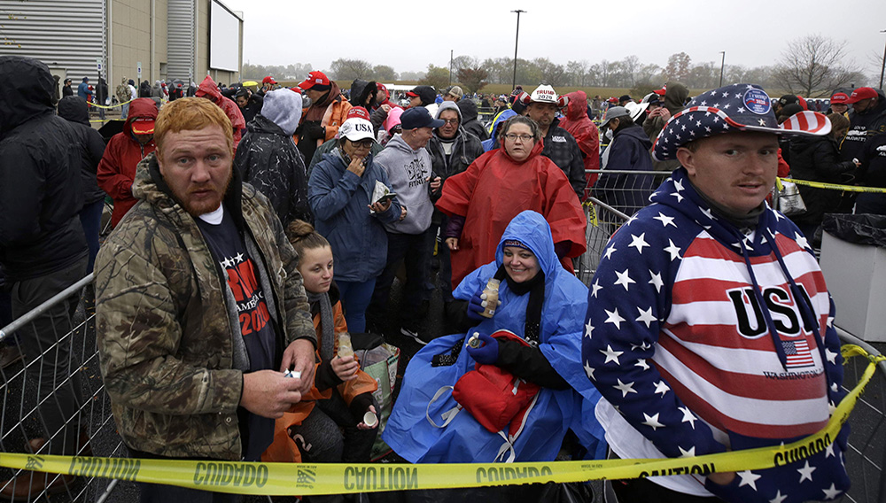 Kyle Terry, 33, front left, stands at the head of the line of supporters waiting to attend a campaign rally for President Donald Trump at Lancaster Airport, Monday, Oct. 26, 2020 in Lititz, Pa. Cynthia Reidler is seen in background. (AP Photo/Jacqueline Larma)