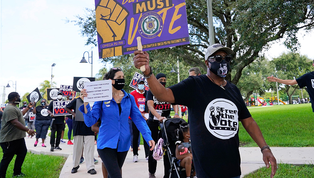 Supporters of restoring Florida felons' voting rights march to an early voting precinct, Saturday, Oct. 24, 2020, in Fort Lauderdale, Fla. The Florida Rights Restoration Coalition led marches to the polls in dozens of Florida counties. (AP Photo/Marta Lavandier)