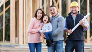 An Hispanic family with a cute little 3 year old daughter, at the construction site where their new home is being built. | Photo: kali9/Getty Images