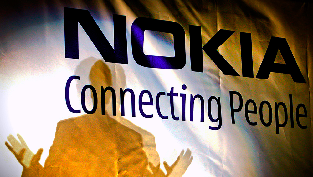 FILE -- In this Feb. 11, 2008 file picture, general manager of the Nokia factory in Romania, John Guerry, casts a shadow on a banner at the new Nokia factory in Jucu, central Romania, during the official opening of the first production line. (AP Photo/Vadim Ghirda, File)