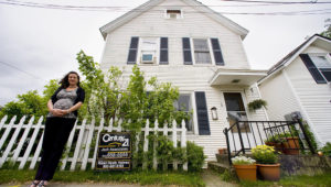 Maura Collins of the Vermont Housing Finance Authority next to a home for sale in Burlington in this file photo from 2011. | Glenn Russell/Free Press