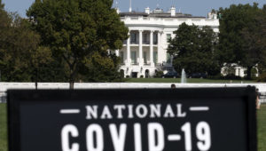 The White House is seen in the background as sign of the National COVID-19 Remembrance, event at The Ellipse outside of the White House, Sunday, Oct. 4, 2020, in Washington. (AP Photo/Jose Luis Magana)
