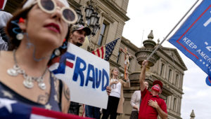 Trump supporters sing the National Anthem while protesting the presidential election results at the State Capitol in Lansing, Michigan, Sunday, Nov. 8, 2020. (AP Photo/David Goldman)