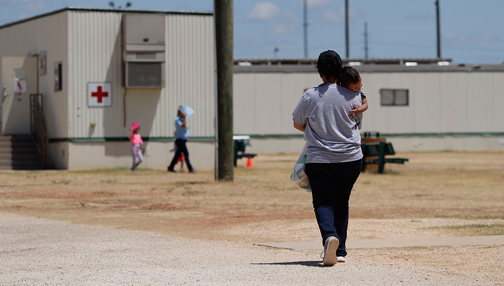 In this Aug. 23, 2019 file photo, immigrants seeking asylum walk at the ICE South Texas Family Residential Center, in Dilley, Texas. (AP Photo/Eric Gay, File)