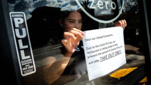 Supervisor Kryztel Natividad posts a notice on the door of Zero X, a coffee and tea cafe, in Riverside on Tuesday, March. 17, 2020, notifying customers of disrupted the service due to outbreak of novel coronavirus (COVID-19). (Photo by Watchara Phomicinda, The Press-Enterprise/SCNG)