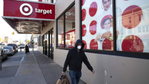 In this April 6, 2020 file photo, a customer wearing a mask carries his purchases as he leaves a Target store during the coronavirus pandemic, in the Brooklyn borough of New York. (AP Photo/Mark Lennihan, File)