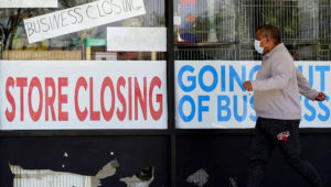 A man looks at signs of a closed store due to COVID-19 in Niles, Ill., May 21, 2020. | Associated Press
