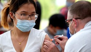 Dree Na Paw, 17, a senior at Washington Technology Magnet School in St. Paul, gets her COVID-19 vaccination shot from volunteer RN Alex Wenzel at a clinic held at the school on Wednesday, August 4, 2021. (John Autey / Pioneer Press)