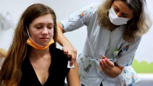 A teenager receives a COVID-19 vaccine dose in Tel Aviv on June 21, after authorities urged parents to get their kids inoculated amid school outbreaks. | © Reuters