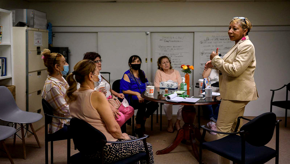 La asistente social Rosa Bramble (derecha), que lidera un grupo de apoyo a trabajadoras hispanos de la Zona Cero tras los atentados del 11/9, conversa con ellas en su consultorio en el distrito neoyorquino de Queens, el 10 de junio de 2021. | Ed JONES/AFP