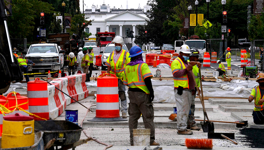 Trabajadores de la construcción reparan una calle cerca de la Casa Blanca en Washington, el 31 de agosto de 2021. | © AFP Olivier Douliery