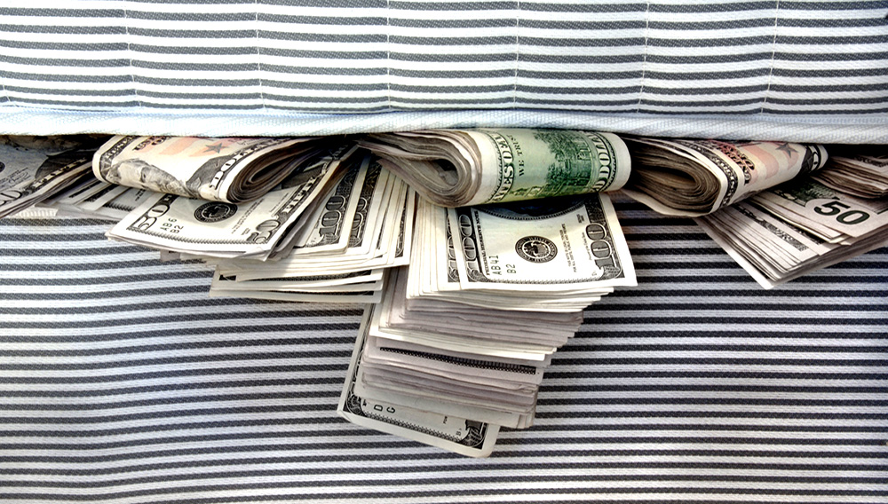 Cash stashed for safe keeping in between mattresses. | Photo via iStock.com/jmbatt