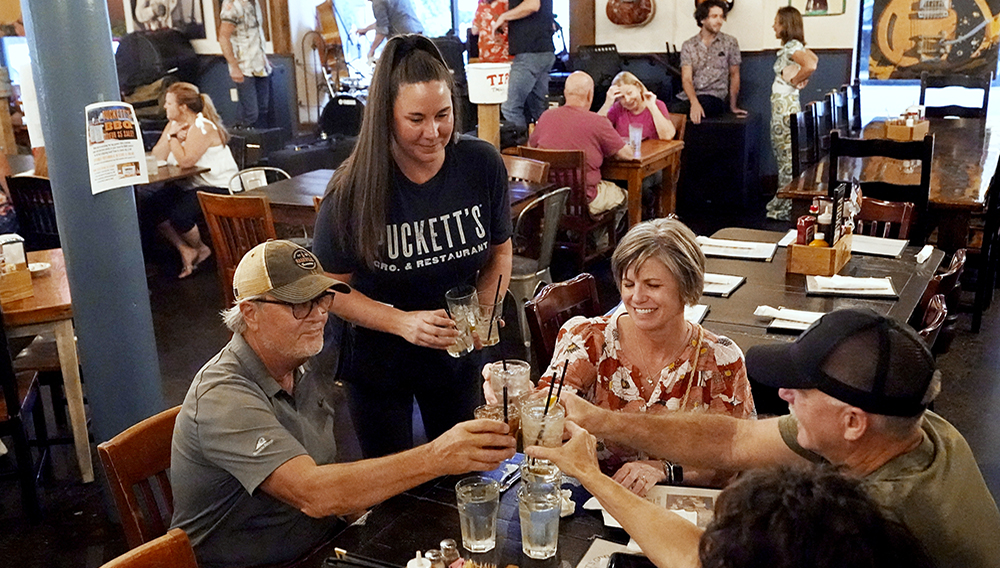Macy Norman, center, serves a table of guests at Puckett's Grocery and Restaurant. | Mark Humphrey, AP