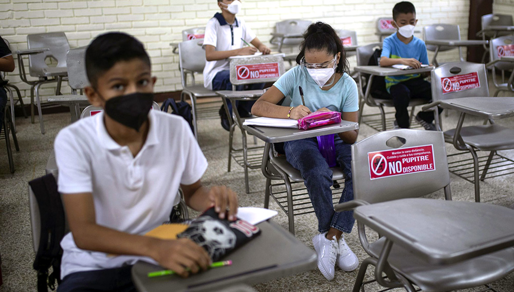 Los estudiantes se sientan con distancia durante la clase presencial en la Escuela Secundaria Técnica Industrial Número 26 de Veracruz, México, el lunes 30 de agosto de 2021, al iniciarse un nuevo año académico durante la pandemia de COVID-19. (AP Foto/Felix Marquez)