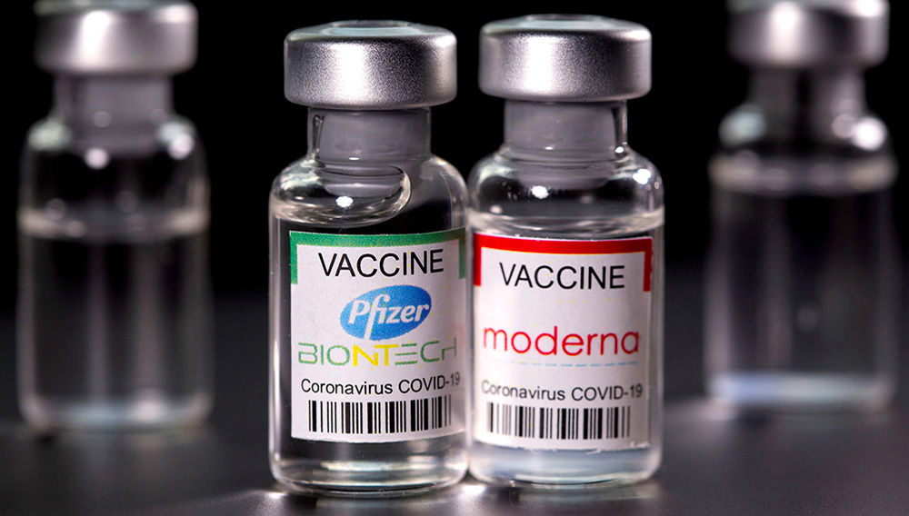 Vials with Pfizer-BioNTech and Moderna coronavirus disease (COVID-19) vaccine labels are seen in this illustration picture taken March 19, 2021. | Dado Ruvic | Reuters