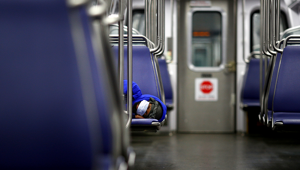 A person rests on a Washington Metro subway car wearing a face mask, following Mayor Muriel Bowser's declaration of a state of emergency due to the coronavirus disease (COVID-19) in Washington, U.S., April 13, 2020. REUTERS/Tom Brenner
