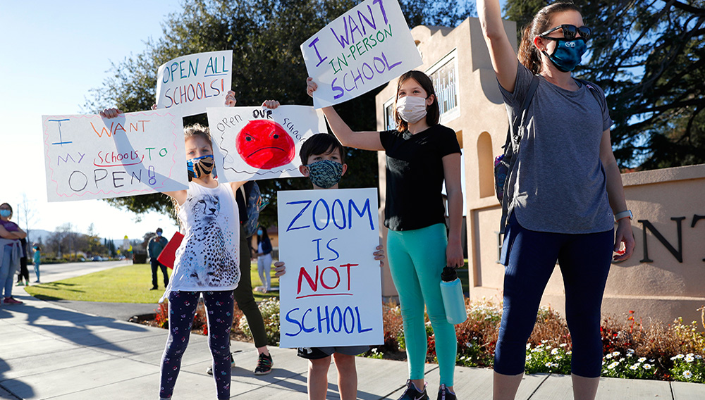 Jill Borges, far right, a teacher at Cupertino High School, protests school closings in the Cupertino and Sunnyvale school districts with her three children, from left to right, Emry, 9, Cruz, 7, and Brooklyn, 13, in front of Fremont High School in Sunnyvale, Calif., on Tuesday, Feb. 23, 2021. (Nhat V. Meyer/Bay Area News Group)