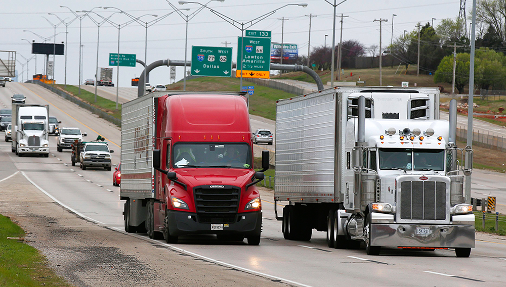 Trucks travel along I-35 in Oklahoma City, Friday, March 20, 2020. (AP Photo/Sue Ogrocki)