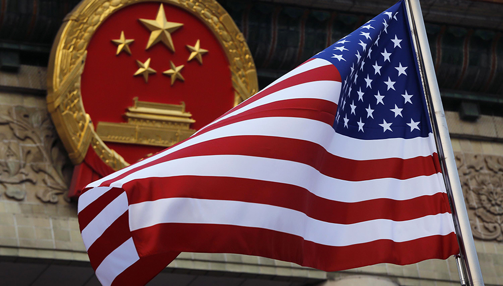 En esta foto del 9 de noviembre del 2017, se ve una bandera estadounidense junto al emblema nacional de China en una ceremonia de bienvenida a visitantes estadounidenses. (AP Foto/Andy Wong)