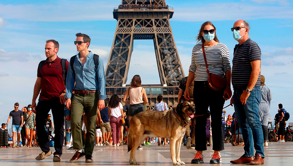 Tourists wear protective masks while visiting the Eiffel Tower on August 2 in Paris, France. | Mehdi Taamallah/NurPhoto/AP
