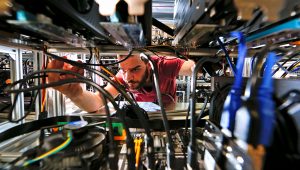 An employee works on bitcoin mining computers at Bitminer factory in Florence, Italy, April 9, 2018. Picture taken April 9, 2018. REUTERS/Alessandro Bianchi