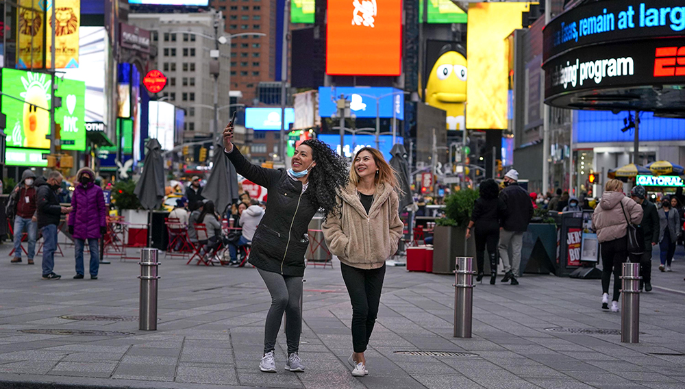 Peatones posan para fotos en Times Square el 15 de noviembre del 2021. (AP Foto/Seth Wenig)