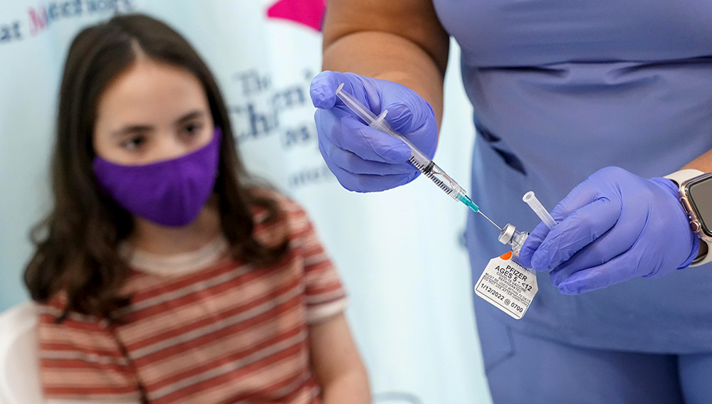 Jamie Onofrio Franceschini, 11, watches as RN Rosemary Lantigua prepares a syringe with her first dose of the Pfizer COVID-19 vaccine for children five to 12 years at The Children's Hospital at Montefiore, Nov. 3, 2021. PHOTO: MARY ALTAFFER, ASSOCIATED PRESS