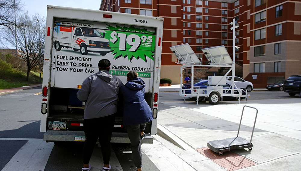 Estudiantes terminan de colocar sus pertenencias en un camión de U-Haul al mudarse de su dormitorio en Washington el 18 de marzo del 2020. (AP Foto/Patrick Semansky)