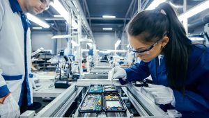 Shot of an Electronics Factory Workers Assembling Circuit Boards by Hand While it Stands on the Assembly Line. PHOTO: AdobeStock.