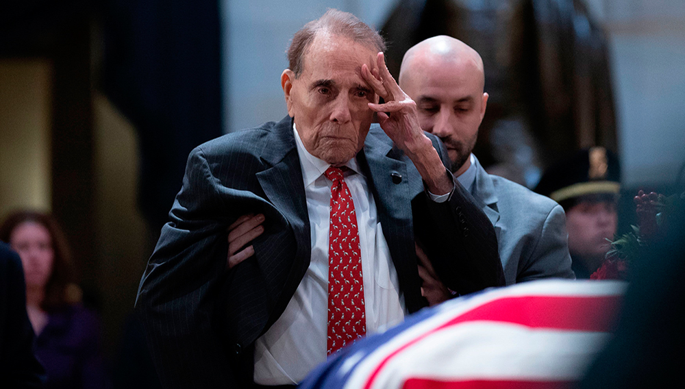Former US Senator Bob Dole salutes before the flag-draped coffin of former US President George H. W. Bush at the US Capitol rotunda December 4, 2018 in Washington, DC. | PHOTO: Alex Edleman | AFP | Getty Images
