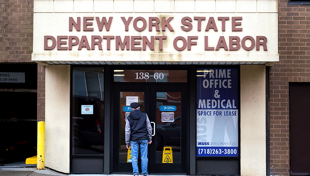 Fotografía de archivo de una persona que lee un cartel en la puerta de una oficina del Departamento de Trabajo del Estado de Nueva York. EFE/EPA/JUSTIN LANE
