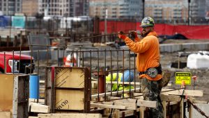 A construction worker prepares a recently poured concrete foundation, Friday, March 17, 2023, in Boston. The Commerce Department issues its third and final estimate of how the U.S. economy performed in the fourth quarter of 2022. (AP Photo/Michael Dwyer)
