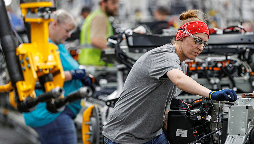 An employee works on an assembly line at startup Rivian Automotive's electric vehicle factory in Normal, Illinois, U.S. REUTERS/Kamil Krzaczynski.