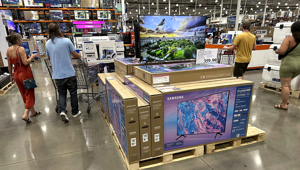 Shoppers glide past a display of big-screen televisions in a Costco warehouse on Tuesday, July 11, 2023, in Sheridan, Colo. (AP Photo/David Zalubowski)