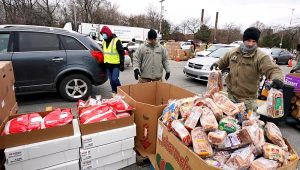 Sgt. Kevin Fowler organizes food at a food bank distribution by the Greater Cleveland Food Bank, Thursday, Jan. 7, 2021, in Cleveland. (AP Photo/Tony Dejak File)