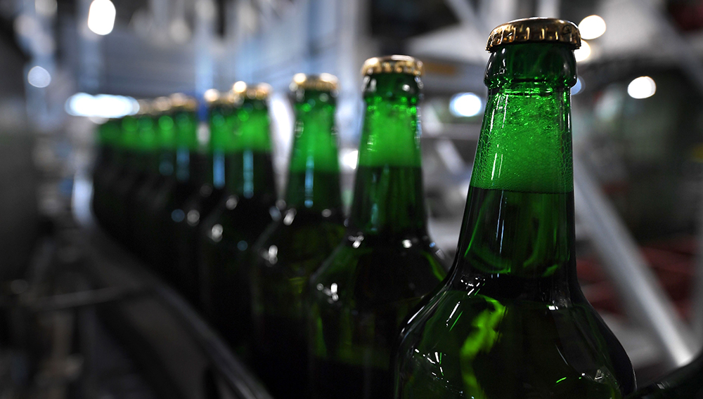 Returnable glass bottles filled with beer sit on a production line at the Meteor brewery in Hochfelden, eastern France, on April 30, 2019. (Photo by PATRICK HERTZOG/AFP via Getty Images)