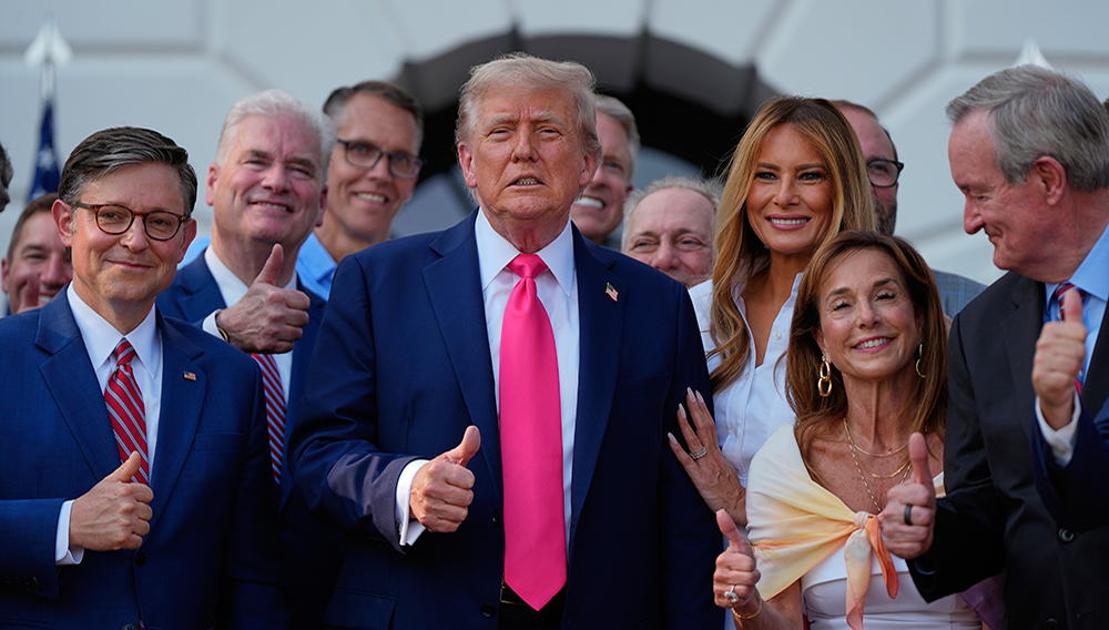 President Donald Trump poses for a photo after signing his signature bill of tax breaks and spending cuts at the White House, Friday, July 4, 2025, in Washington, surrounded by members of Congress, including House Speaker Mike Johnson of La., left. (AP Photo/Julia Demaree Nikhinson)