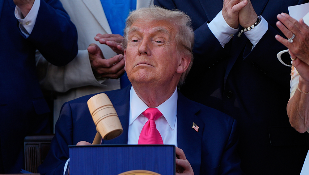 President Donald Trump holds a gavel after he signed his signature bill of tax breaks and spending cuts at the White House, Friday, July 4, 2025, in Washington, surrounded by members of Congress. (AP Photo/Julia Demaree Nikhinson)