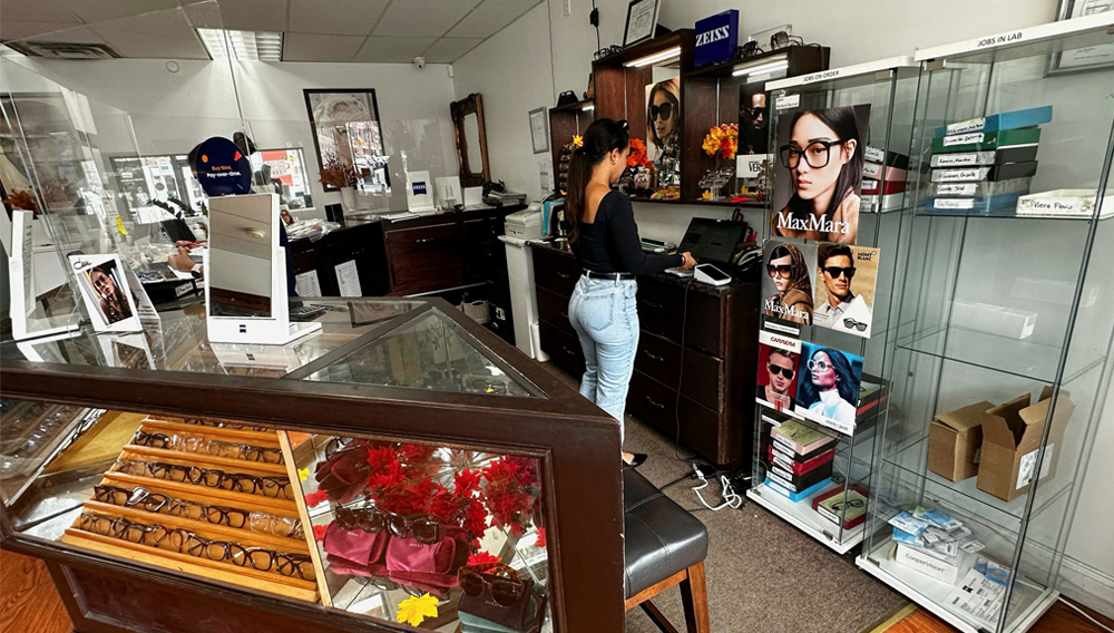Valerie Bandras tends to a display of eyeglass frames at her store, Urban Eyes Vision Center, in the heavily Latino Ironbound section of Newark, New Jersey, U.S., September 16, 2025. REUTERS/Nicholas P. Brown