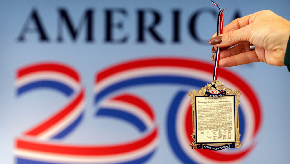Jennifer Condon, Executive Vice President of America250, displays the front of a commemorative ornament released by America250 as part of events leading up to the 250th anniversary of the signing of the Declaration of Independence in 1776, is photographed Thursday, Nov. 13, 2025, in Washington. (AP Photo/Mark Schiefelbein)