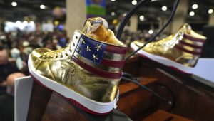 Gold Trump sneakers sit on the podium after Republican presidential candidate former President Donald Trump spoke at Sneaker Con Philadelphia, an event popular among sneaker collectors, and announces a gold Trump sneaker, in Philadelphia, Saturday, Feb. 17, 2024. (AP Photo/Manuel Balce Ceneta)