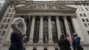 People walk past the New York Stock Exchange, Friday, March 27, 2026, in New York. (AP Photo/Yuki Iwamura)