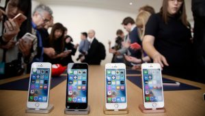 In this March 21, 2016, file photo members of the media and invited guests take a look at the new iPhone SE during an event at Apple headquarters in Cupertino, Calif. (AP Photo/Marcio Jose Sanchez)