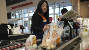 A employee works at a cash register in a grocery store in Schaumburg, Ill., Thursday, May 14, 2026. (AP Photo/Nam Y. Huh)