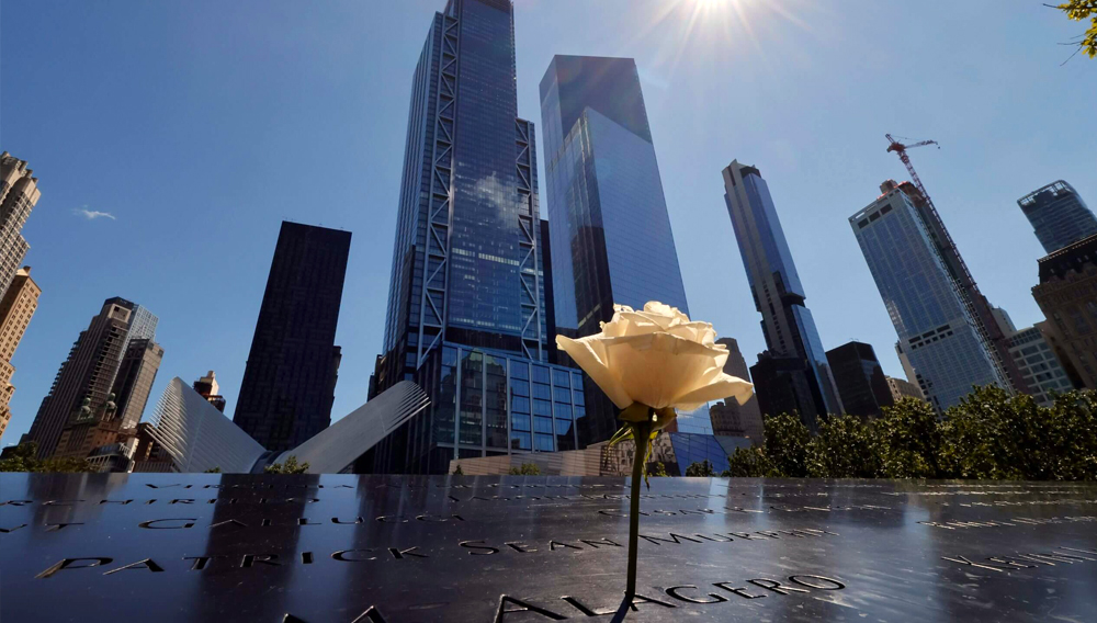 A rose stands on the 9/11 Memorial for the North Tower in front of 3 and 4 World Trade Center. Gary Hershorn / Getty Images